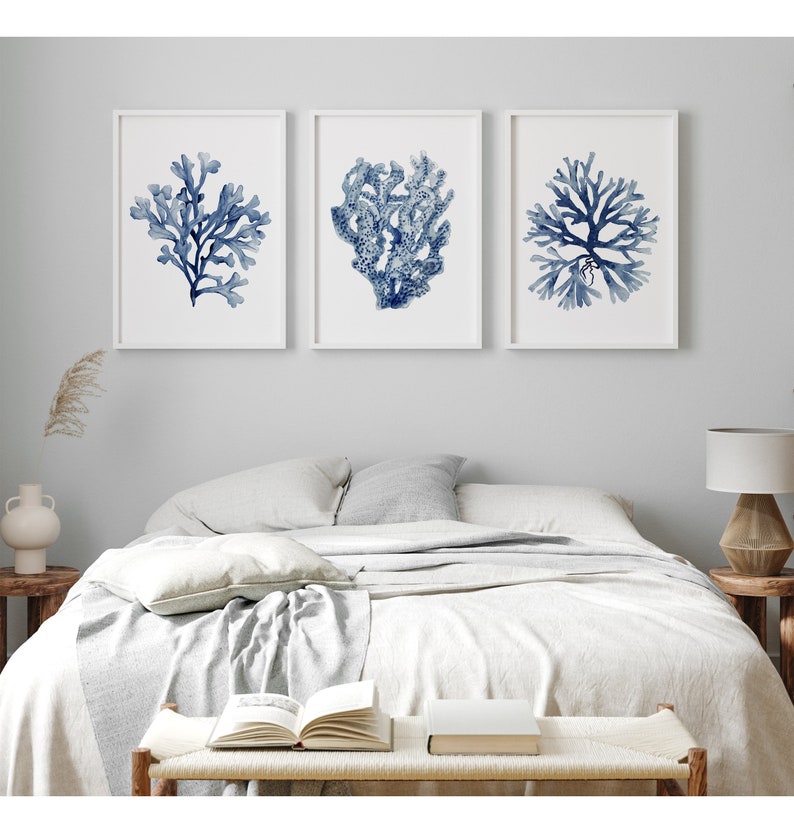 Set of 3 prints in white frames depicting corals and seaweed hang in a hamptons bedroom. Posters are available in all sizes.