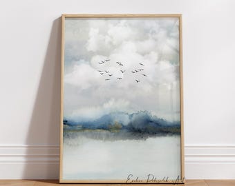 May include: A framed watercolor landscape print featuring a serene scene with a flock of birds flying across a cloudy sky. The artwork has a soft color palette of blues, grays, and whites, with a wooden frame.