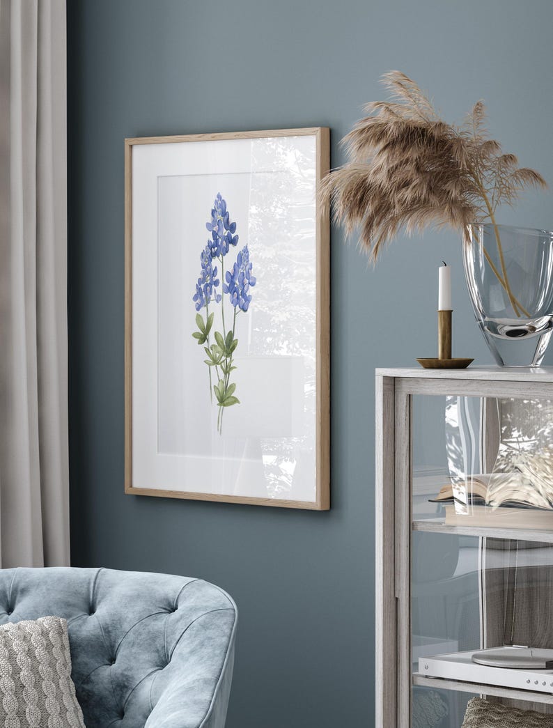 K&ouml;nnte beinhalten: Ein gerahmtes Aquarellbild von Blausternblumen, einer Wildblumenart, die in Texas heimisch ist, vor einem wei&szlig;en Hintergrund. Der Rahmen ist aus hellem Holz.