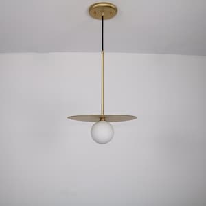 May include: A gold pendant light with a white globe shade and a flat, circular canopy.