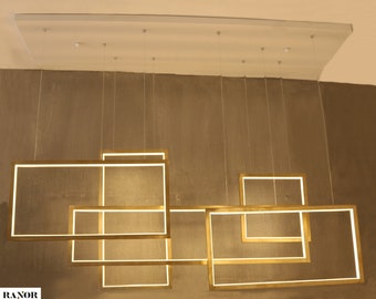 May include: Modern rectangular chandelier with a gold finish and integrated LED lighting. The fixture features multiple interconnected frames suspended from the ceiling, creating a contemporary lighting design. The light is bright and even, suitable for various interior spaces.