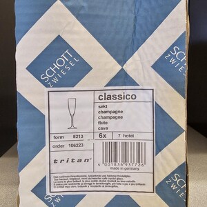 May include: A cardboard box with a blue and white diamond pattern. The box contains Schott Zwiesel Classico champagne flutes. The label indicates the glasses are made in Germany.