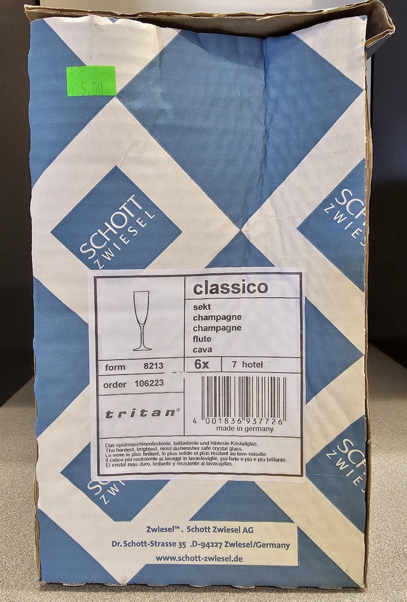 May include: A cardboard box with a blue and white diamond pattern. The box contains Schott Zwiesel Classico champagne flutes. The label indicates the glasses are made in Germany.