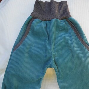 Puede incluir: Pantal&oacute;n de pana turquesa con cintura gris. El pantal&oacute;n tiene bolsillos laterales.