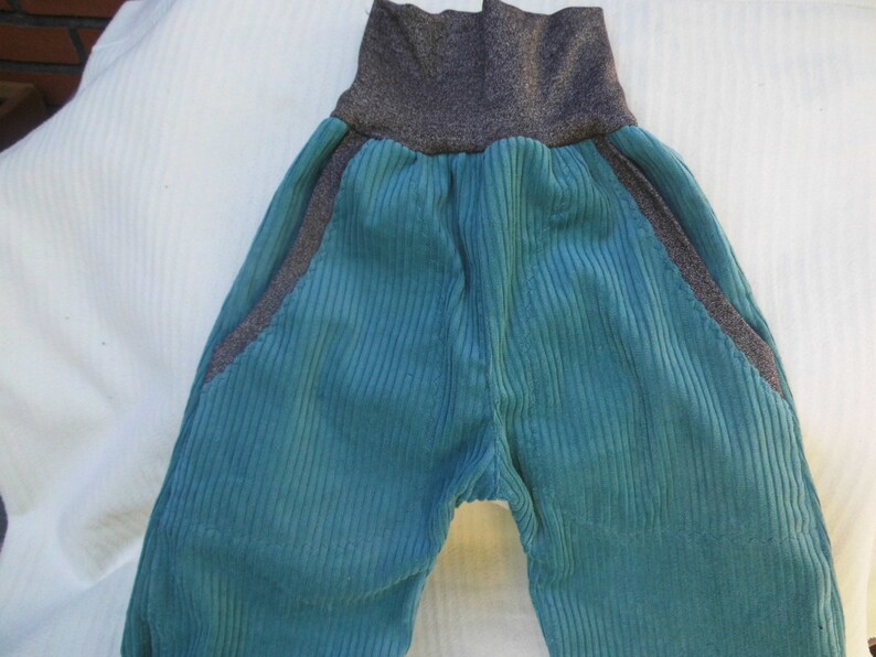 Puede incluir: Pantal&oacute;n de pana turquesa con cintura gris. El pantal&oacute;n tiene bolsillos laterales.