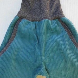 Puede incluir: Pantalones de pana turquesa con cintura y paneles laterales de punto gris.