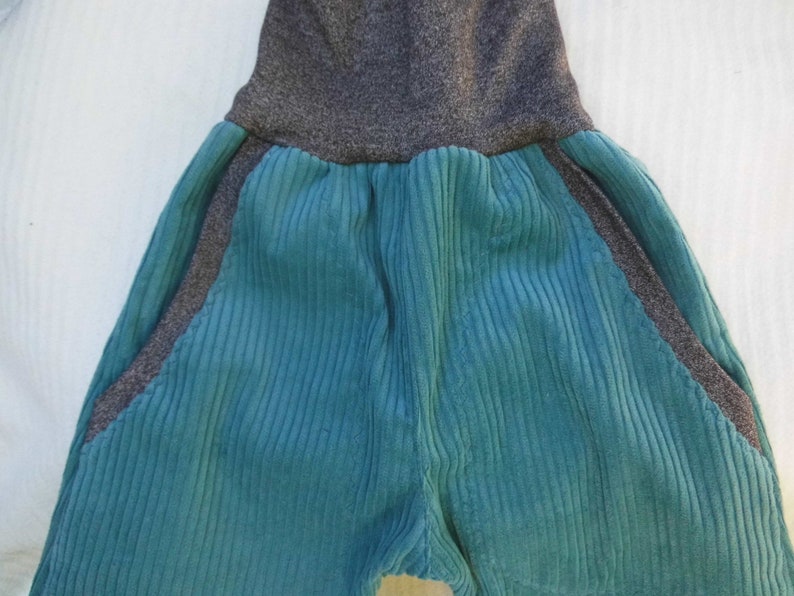 Puede incluir: Pantalones de pana turquesa con cintura y paneles laterales de punto gris.