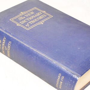 May include: A vintage hardcover book titled "The New Dictionary of Thoughts" in a deep blue color. The title is in gold lettering within a rectangular frame. The book is from Standard Book Co.