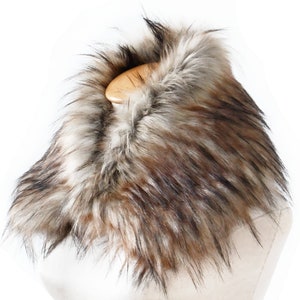 Puede incluir: Un cuello de piel sint&eacute;tica en marr&oacute;n, negro y blanco. El cuello est&aacute; hecho de piel suave y esponjosa y es perfecto para a&ntilde;adir un toque de calidez y estilo a cualquier atuendo.