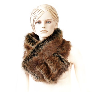 May include: A brown and black faux fur scarf with a long, flowing design. The scarf is worn around the neck of a mannequin.