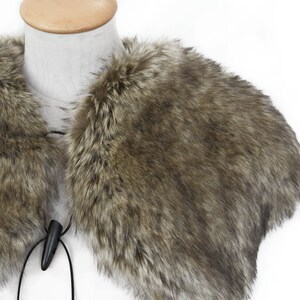 May include: A brown faux fur collar with a black cord and wooden toggle closure.