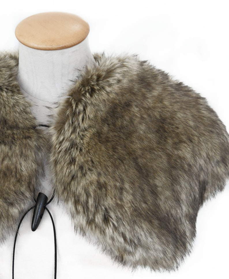May include: A brown faux fur collar with a black cord and wooden toggle closure.