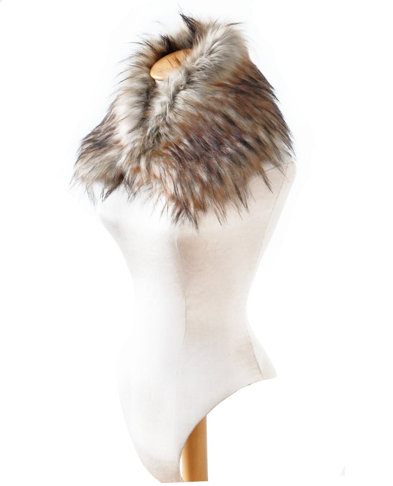 Puede incluir: Un collar de piel sint&eacute;tica marr&oacute;n y blanco. El collar est&aacute; en un maniqu&iacute; blanco.