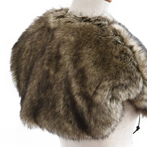May include: A brown faux fur shawl with a short, cropped length. The shawl is made of soft, fluffy faux fur and has a simple, elegant design.