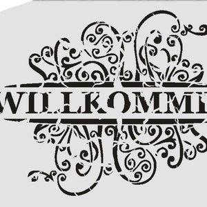 May include: Black and white stencil with a decorative floral design and the word "WILLKOMMEN" in a distressed font.