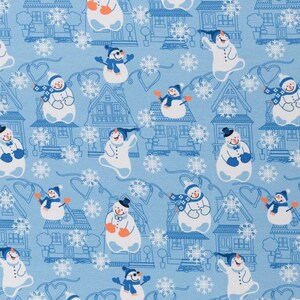 Könnte beinhalten: Ein blauer und weißer Stoff mit einem sich wiederholenden Muster aus Schneemännern, Häusern und Schneeflocken. Die Schneemänner tragen Schals und Hüte, und die Häuser haben Schornsteine und Fenster.