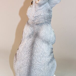 May include: A gray ceramic rabbit figurine with a fluffy texture. The rabbit is sitting with its ears up and its tail tucked behind it.