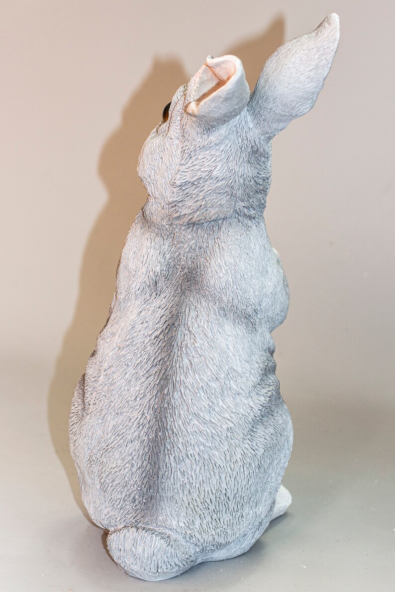 May include: A gray ceramic rabbit figurine with a fluffy texture. The rabbit is sitting with its ears up and its tail tucked behind it.