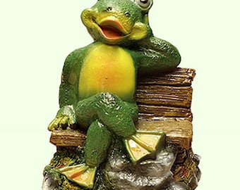 Könnte beinhalten: Ein grüner Frosch mit gelben Flecken sitzt entspannt auf einer Holzbank. Der Frosch hält sich mit einer Hand den Kopf und hat die Beine übereinandergeschlagen. Die Bank ist aus Holz und hat einen rustikalen Look. Der Frosch sitzt auf einem Stein.
