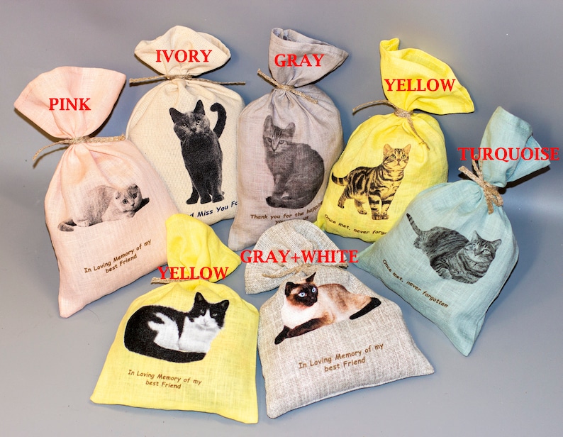 Puede incluir: Surtido de peque&ntilde;as bolsas de tela en varios colores, cada una con una imagen de gato diferente y un mensaje conmemorativo. Los colores incluyen rosa, marfil, gris, amarillo, turquesa y gris y blanco. Los mensajes incluyen "En memoria de mi mejor amigo", "Te extra&ntilde;o para siempre", "Gracias por el amor" y "Una vez conocido, nunca olvidado".