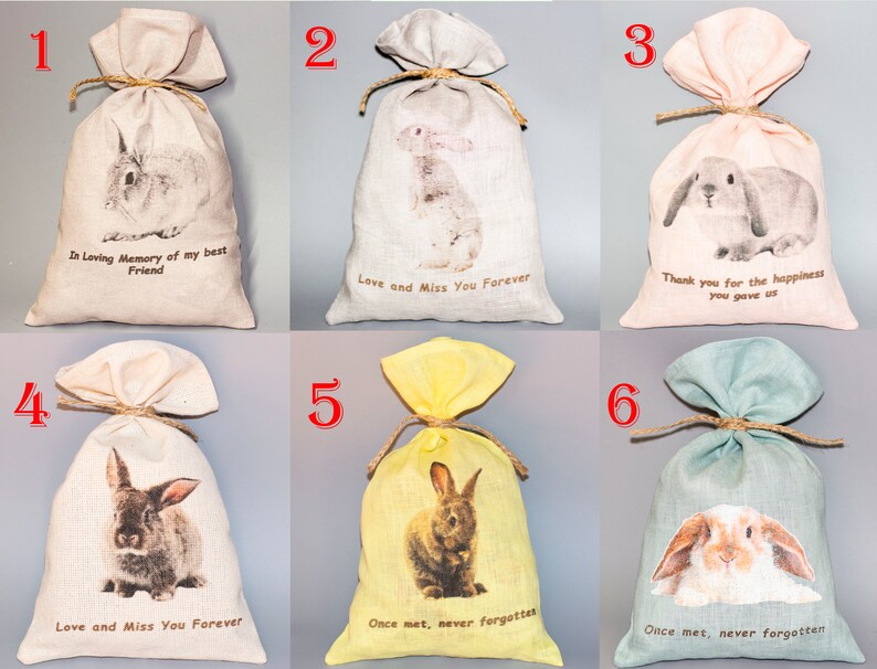 May include: Six small burlap bags with bunny rabbit images and text. The bags are in various colors, including beige, pink, yellow, and green. The text on the bags includes "In Loving Memory of my best Friend", "Love and Miss You Forever", "Thank you for the happiness you gave us", and "Once met, never forgotten".