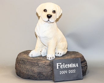 May include: White ceramic figurine of a Labrador Retriever puppy sitting on a brown rock base. A black plaque with the text "Felemina 2004-2022" is attached to the base.