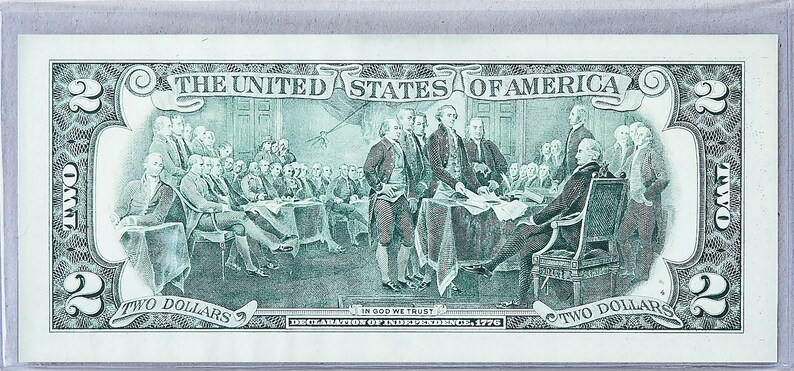 May include: A green two dollar bill featuring a depiction of the signing of the Declaration of Independence. The text "THE UNITED STATES OF AMERICA", "IN GOD WE TRUST", "DECLARATION OF INDEPENDENCE, 1776", and "TWO DOLLARS" is visible on the bill.