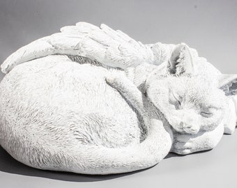 May include: White ceramic figurine of a cat with wings, sleeping curled up. The cat has a detailed face and fur texture.