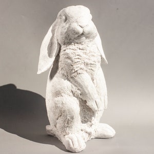 Op de afbeelding: Witte keramische konijnenfiguur met lange oren en een pluche textuur. Het konijn staat rechtop met zijn poten bij elkaar.