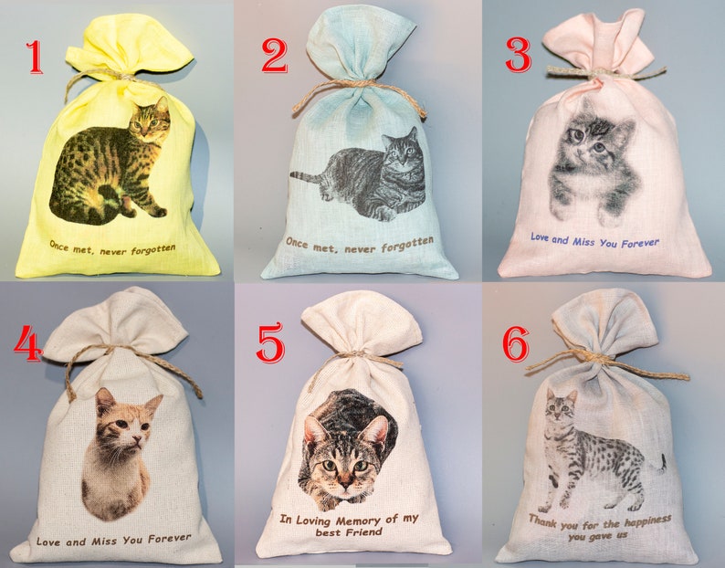 Op de afbeelding: Zes kleine jute zakken met verschillende kattenafbeeldingen en tekst. De zakken zijn vastgebonden met touw en hebben verschillende kleuren, waaronder geel, blauw, roze en beige. De tekst op de zakken is "Once met, never forgotten", "Love and Miss You Forever" en "In Loving Memory of my Best Friend".