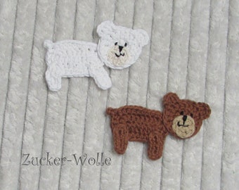Puede incluir: Dos aplicaciones de oso de crochet, una blanca y otra marrón, con ojos negros y una nariz negra. Los osos están sobre un fondo blanco peludo con el texto "Zucker-Wolle" en negro.