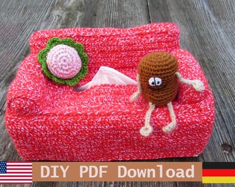 May include: A red and white crocheted tissue box cover shaped like a small sofa. It features a green and pink crocheted flower on the left armrest and a small brown crocheted character with white eyes and thin limbs sitting on the right side.