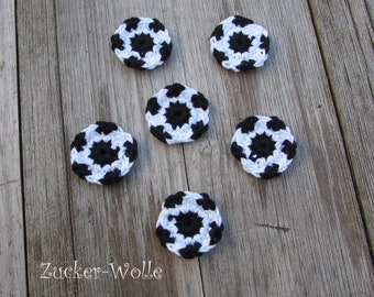 Puede incluir: Seis posavasos de ganchillo en blanco y negro con un diseño de balón de fútbol. Los posavasos están sobre una superficie de madera. Zucker-Wolle está escrito en la superficie.