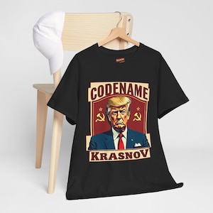 May include: Black t-shirt with a graphic of Donald Trump in a suit with the text "CODENAME KRASNOV" and two red communist stars and hammers.