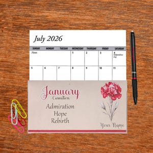 May include: A July 2026 calendar with a floral design bookmark for January. The bookmark features a red carnation with the words "January - Carnation, Admiration, Hope, Rebirth, Your Name".