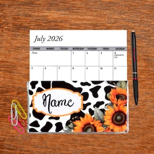 May include: A July 2026 calendar with a cow print and sunflower design. The calendar has a space for notes and a nameplate that says "Name".