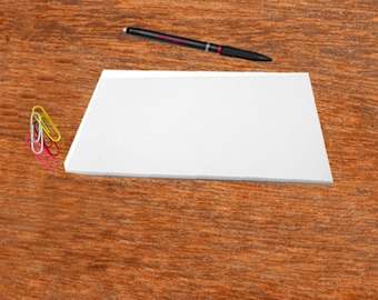 May include: A white sheet of paper on a wooden surface with a black pen and a stack of colorful paper clips.