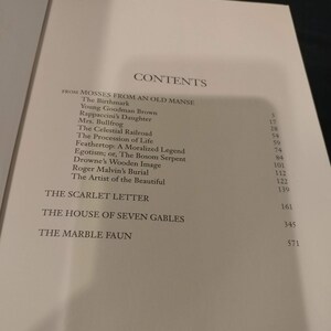 Pode incluir: Um livro intitulado "Mosses from an Old Manse" de Nathaniel Hawthorne. O livro cont&eacute;m uma tabela de conte&uacute;do listando os t&iacute;tulos das hist&oacute;rias e seus n&uacute;meros de p&aacute;gina. As hist&oacute;rias incluem "The Birthmark", "Young Goodman Brown", "Rappaccini's Daughter", "Mrs. Bullfrog", "The Celestial Railroad", "The Procession of Life", "Feathertop: A Moralized Legend", "Egotism; or, The Bosom Serpent", "Drowne's Wooden Image", "Roger Malvin's Burial", "The Artist of the Beautiful", "The Scarlet Letter", "The House of Seven Gables" e "The Marble Faun".
