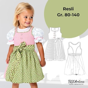May include: A young girl wearing a traditional dirndl dress. The dress features a pink gingham bodice, a green floral skirt, and a green bow. The sleeves are white lace. The image also includes a diagram of the dress and the text "Resli Gr. 80-140".