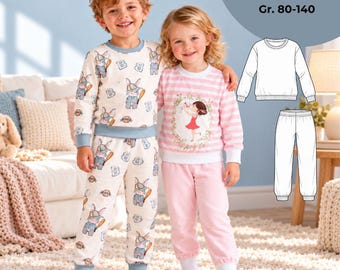May include: Two-piece pajama sets featuring long-sleeved tops and pants with ribbed cuffs. One set has a cream background with a repeating rabbit and letter B print. The other set has pink and white horizontal stripes with a central girl graphic.