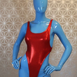 Op de afbeelding: Een rood metallic badpak met een hoge beenuitsnijding en een ronde hals.