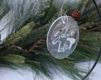 May include: A clear glass bauble with the text "Salon Life" and a hairdryer graphic etched on it. The bauble is hanging from a silver string.