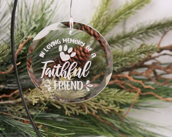 May include: A clear glass bauble with a white paw print and the text "In loving memory of a Faithful Friend".