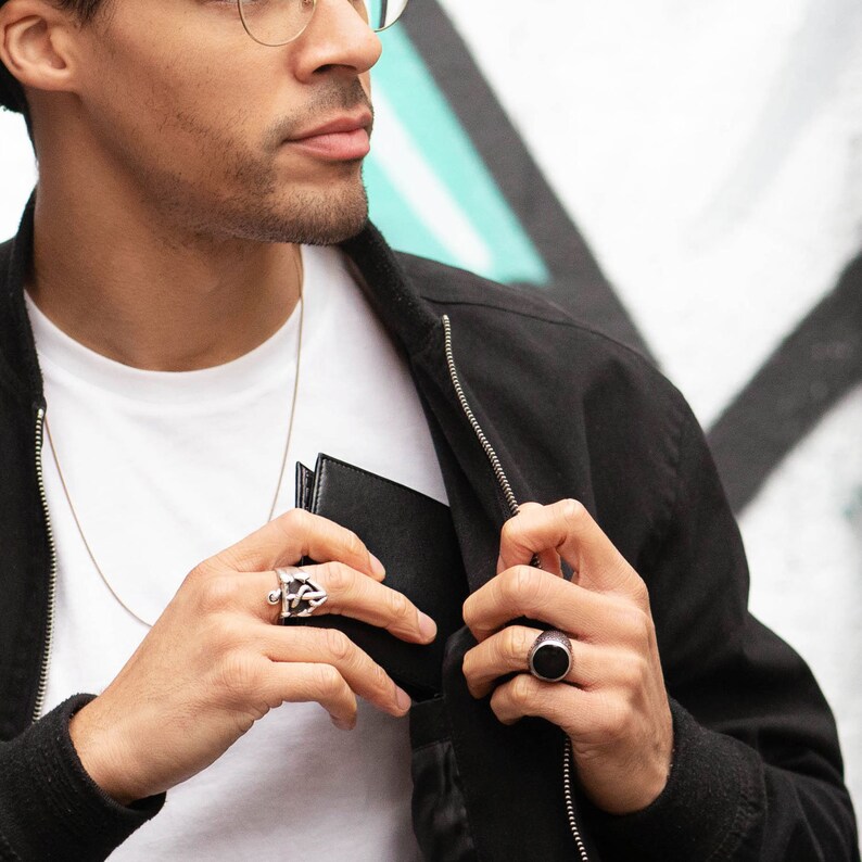 A person holds a black bifold coin wallet.