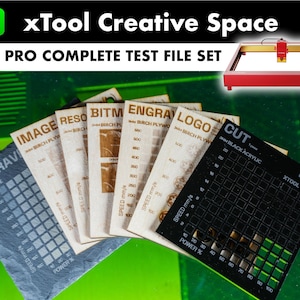May include: A set of test files for a laser engraver, including samples of engraving on birch plywood, acrylic, and slate. The files are labeled with the material type and the engraving settings used. The laser engraver is also shown in the image.