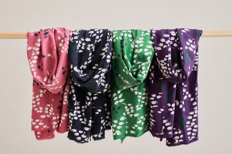 Pu&ograve; includere: Quattro sciarpe in tessuto con una stampa astratta bianca e verde. Le sciarpe sono in tonalit&agrave; rosa, blu scuro, verde e viola.