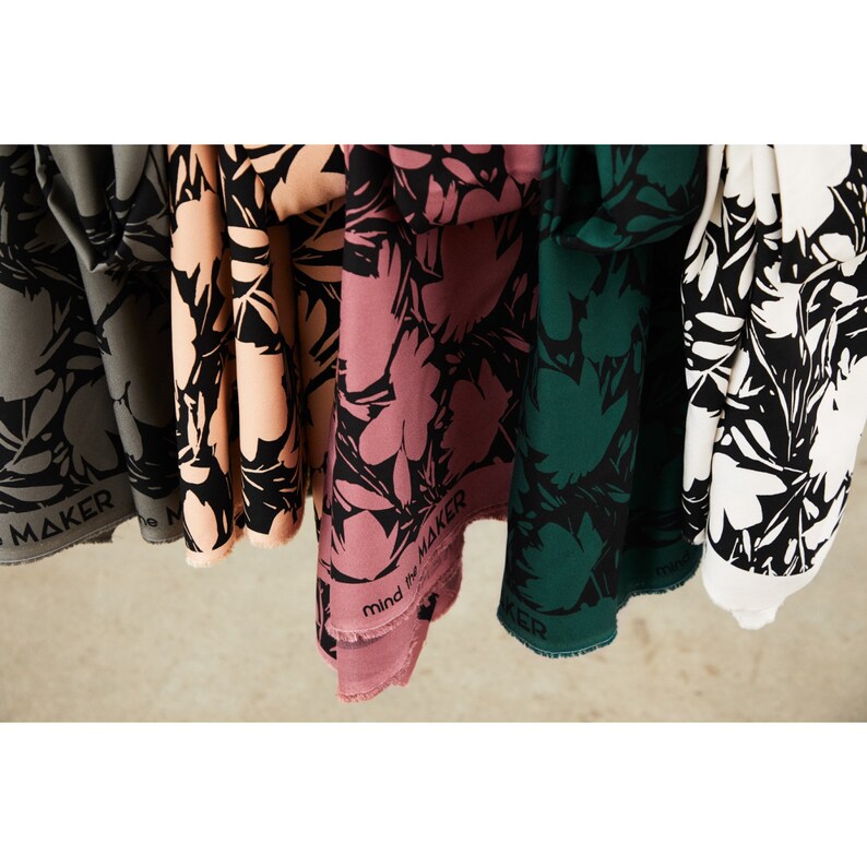 Puede incluir: Cinco muestras de tela con un estampado floral en blanco y negro. Las muestras son de color gris, melocot&oacute;n, rosa, verde y blanco. El texto "Mind the Maker" est&aacute; impreso en la muestra rosa.