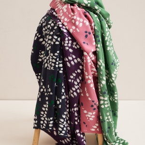 Pu&ograve; includere: Quattro campioni di tessuto con un motivo astratto di pennellate bianche su uno sfondo verde, rosa, viola e blu navy.