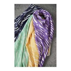 May include: Four fabric swatches with a white and colored abstract pattern. The swatches are in shades of blue, green, yellow, and purple.