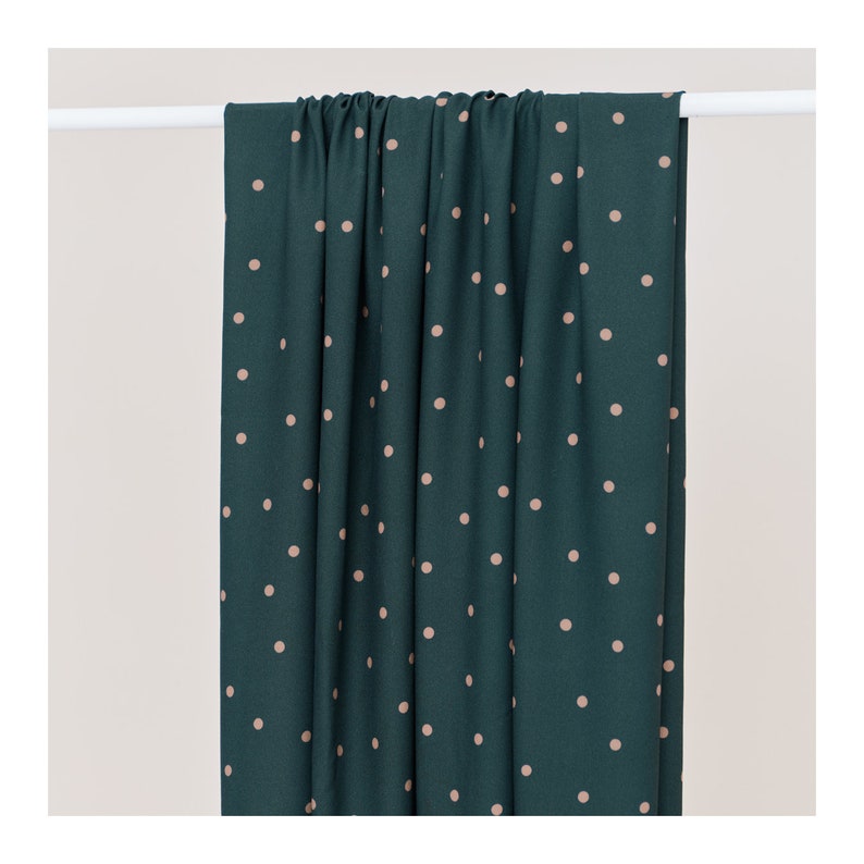 May include: A teal fabric with a white polka dot pattern. The fabric is smooth and has a subtle sheen.
